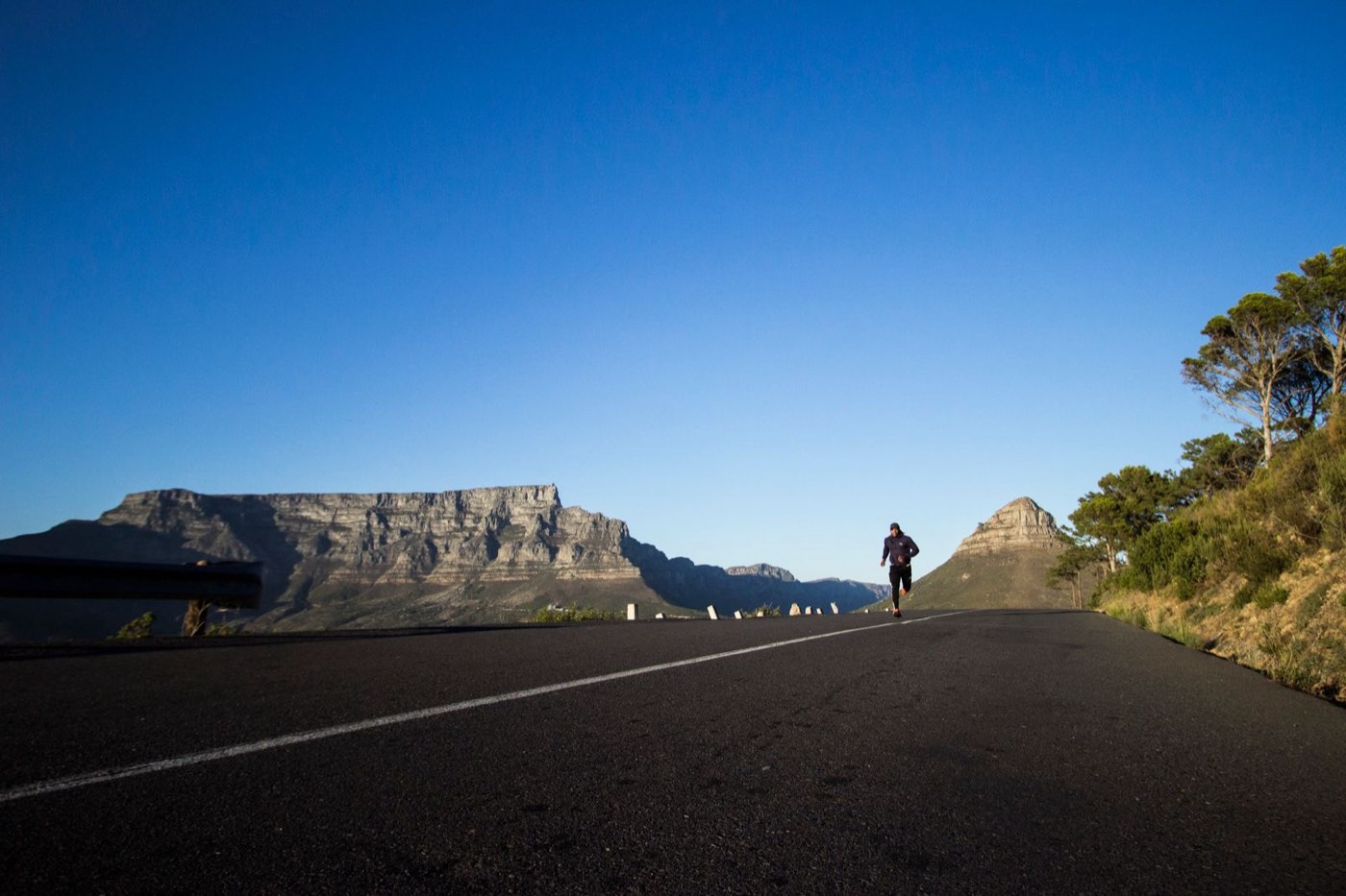 A runner alone on a mountain road
